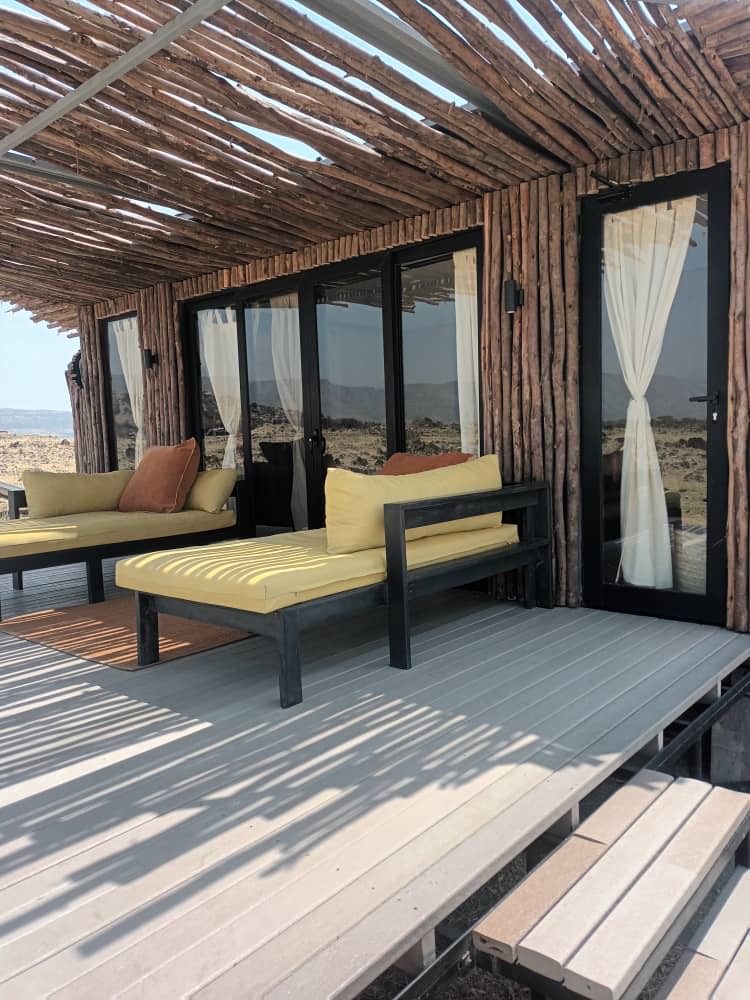 Shaded lounge terrace on a recycled plastic deck outside a safari villa