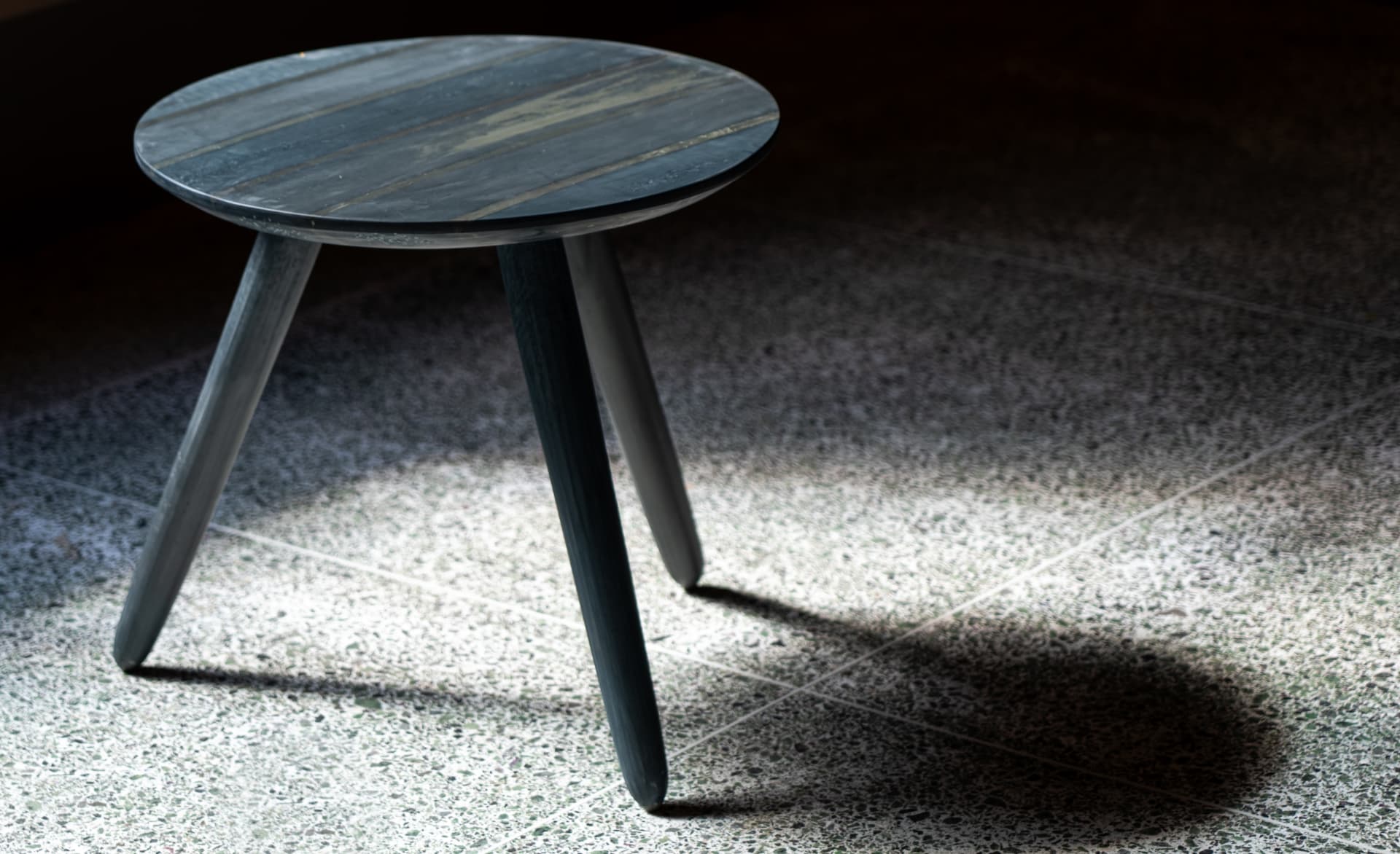 Charcoal recycled plastic round side table lit from the side