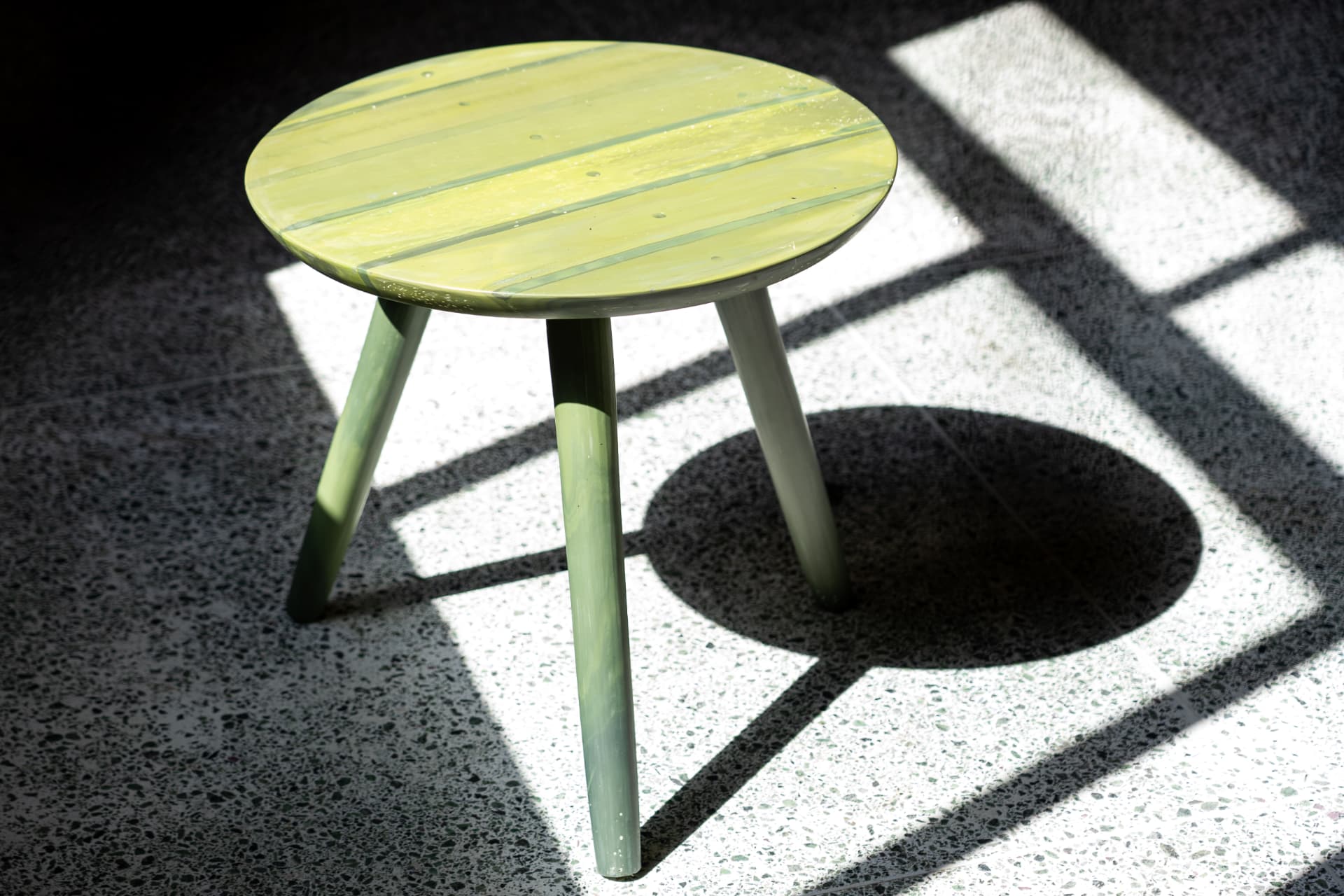 Lime pour recycled plastic side table in raking sunlight